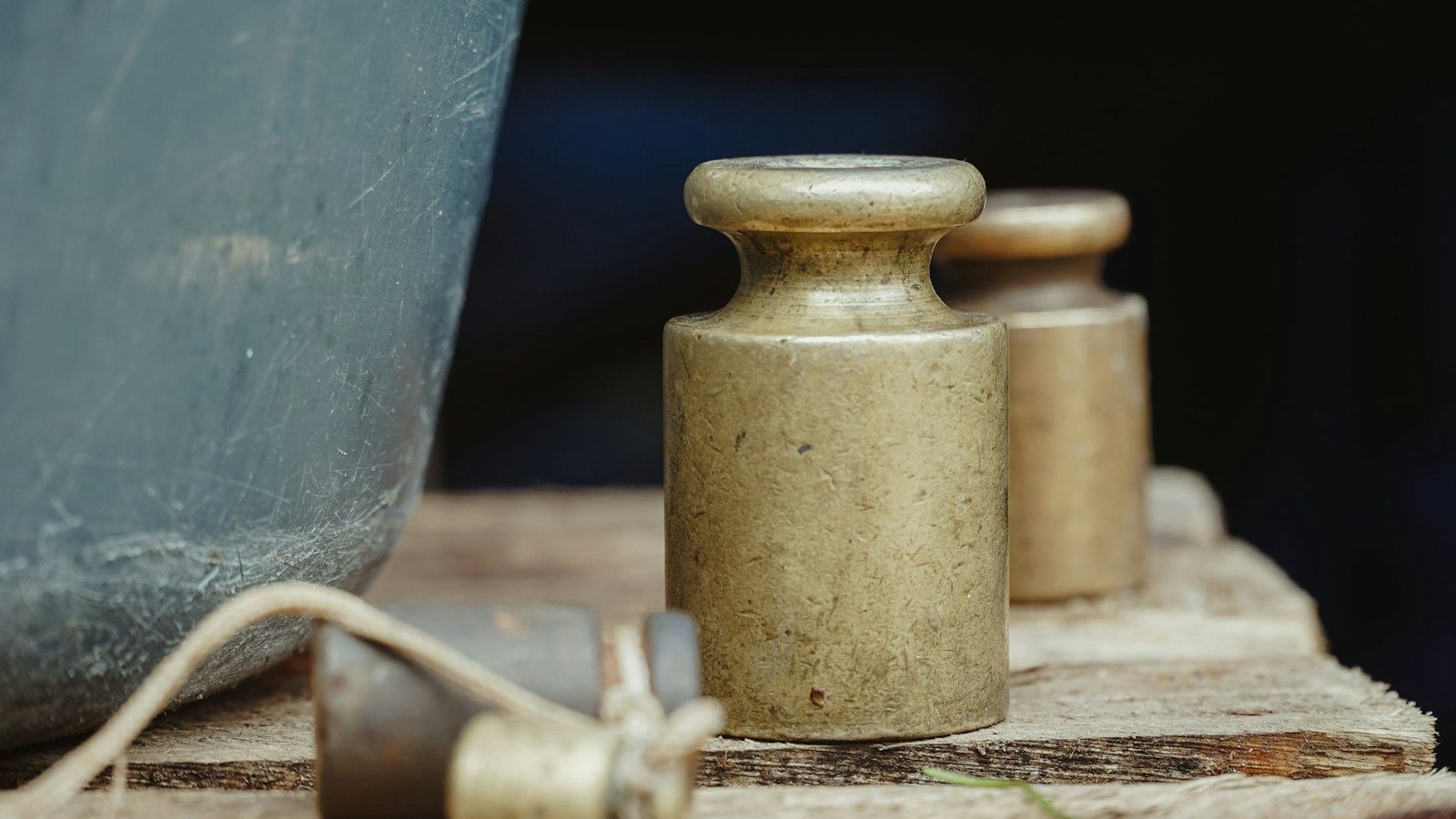 Pesas de latón antiguas sobre una tabla de madera
