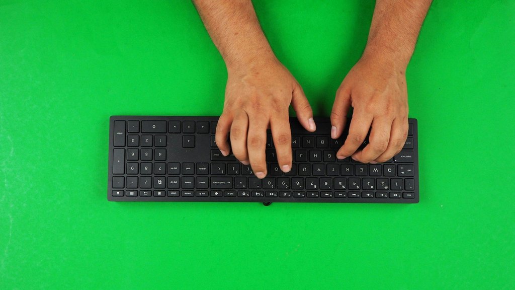 Manos en posición de mecanografía sobre un teclado negro